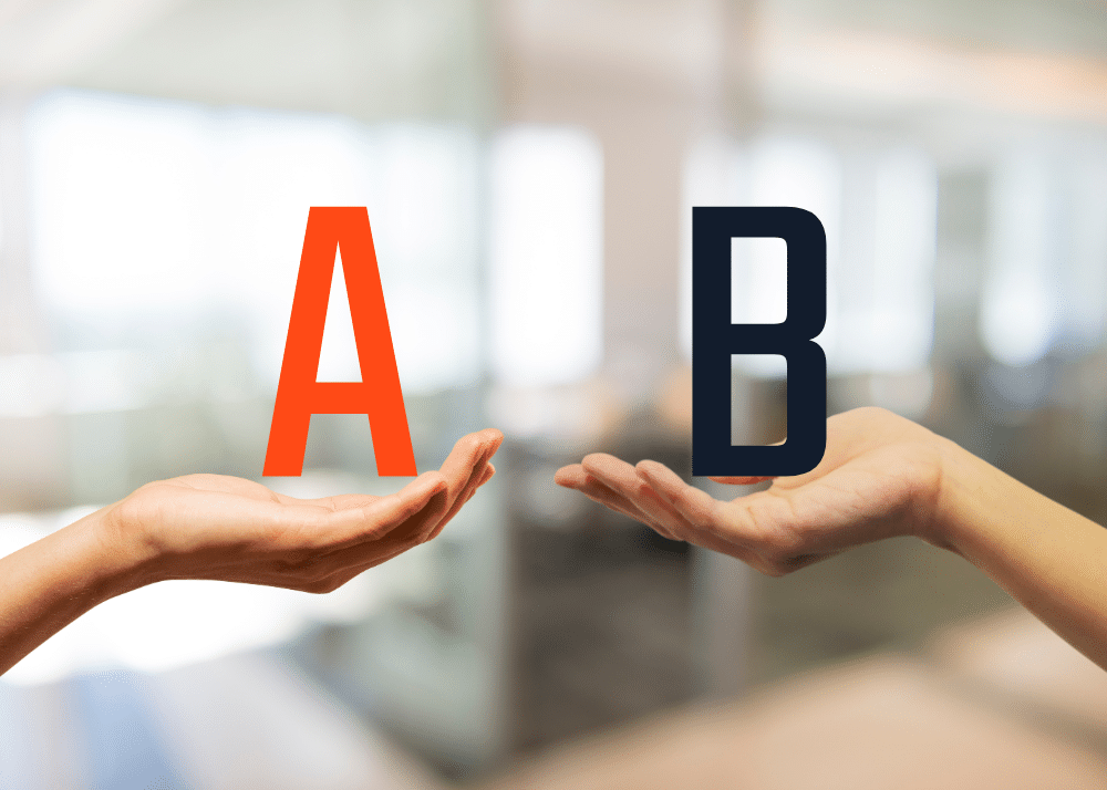 Zwei Hände halten die Buchstaben A und B in einem unscharfen Bürohintergrund.